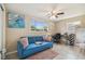 Cozy living room featuring a plush blue sofa, natural light, and stylish decor at 10817 Kingsbridge Rd, Port Richey, FL 34668