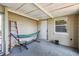 An enclosed patio area with a hammock, access to outside, and a small window for natural light at 10817 Kingsbridge Rd, Port Richey, FL 34668