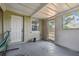 A covered patio area featuring a door for access to the outside and a window for natural light at 10817 Kingsbridge Rd, Port Richey, FL 34668