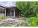 View of the screened-in patio and backyard area with mature trees and Florida foliage at 11536 Baywood Meadows Dr # 3, New Port Richey, FL 34654
