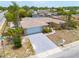 An aerial view showcasing the home's layout, driveway, and surrounding neighborhood with lush greenery at 1170 Chelsea Ln, Holiday, FL 34691