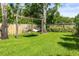 Serene backyard featuring a hammock, lush green grass, and a wooden fence for added privacy and relaxation at 11804 Carrollwood Village Cv, Tampa, FL 33618