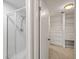 Clean, tiled bathroom with a glass-enclosed shower and custom shelving in walk-in closet at 11804 Carrollwood Village Cv, Tampa, FL 33618
