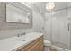 Bathroom with a glass shower, chandelier, and a silver framed mirror at 11804 Carrollwood Village Cv, Tampa, FL 33618