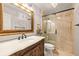 Bathroom featuring a vanity with granite countertops and a glass-enclosed shower at 11804 Carrollwood Village Cv, Tampa, FL 33618