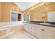 Bathroom with double vanity, garden tub, chandelier, and bright natural light at 11804 Carrollwood Village Cv, Tampa, FL 33618