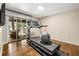 Modern exercise room featuring a treadmill, wood floors, and access to outdoor entertaining space at 11804 Carrollwood Village Cv, Tampa, FL 33618