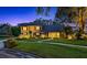 Charming two-story home featuring a lush, green lawn, mature trees, and well-lit exterior at 11804 Carrollwood Village Cv, Tampa, FL 33618