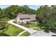 Inviting exterior of a two-story home showcasing a well-manicured lawn, mature trees, and a long driveway at 11804 Carrollwood Village Cv, Tampa, FL 33618