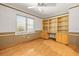 Office featuring hardwood floors, built-in bookshelves, and a large window for natural light at 11804 Carrollwood Village Cv, Tampa, FL 33618
