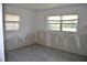 This bedroom features two windows and gray tiled floors, a canvas for transformation and renovation at 119 18Th Nw St, Ruskin, FL 33570
