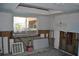 Kitchen needing repair, showing bare studs, a window, and tile flooring at 119 18Th Nw St, Ruskin, FL 33570