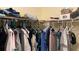 Walk-in closet with clothing on hangers and stacked on shelves at 12328 Shafton Rd, Spring Hill, FL 34608