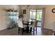 Bright dining area with glass table and modern chairs, next to a glass cabinet and view of the pool at 12328 Shafton Rd, Spring Hill, FL 34608