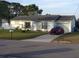 Charming single-story home with a well-maintained lawn and a long concrete driveway with a red car at 12328 Shafton Rd, Spring Hill, FL 34608