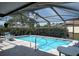 Screened-in pool area with lounge chairs and mature landscaping at 12328 Shafton Rd, Spring Hill, FL 34608