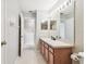 Neutral bathroom with light wood cabinets, vanity, large mirror, and tile flooring provides a clean aesthetic at 12443 Country White Cir, Tampa, FL 33635
