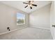 Cozy bedroom with neutral carpet and paint, and a tranquil view of the surrounding neighborhood at 12443 Country White Cir, Tampa, FL 33635