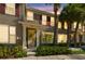 Charming townhome exterior featuring lush palm trees, red shutters, and a decorative front door at 12443 Country White Cir, Tampa, FL 33635