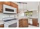 Functional kitchen with white appliances, wood cabinetry, and views into the adjacent living space at 12443 Country White Cir, Tampa, FL 33635