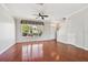Bright living room featuring hardwood floors, a ceiling fan, and a large window at 12443 Country White Cir, Tampa, FL 33635
