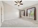 Bright primary bedroom featuring neutral carpet, ceiling fan, and natural light from two windows at 12443 Country White Cir, Tampa, FL 33635