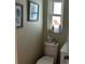 This half bathroom features decorations, a modern toilet, and a stylish vanity with a window at 12478 Capri Circle N # 2, Treasure Island, FL 33706