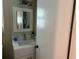 A well-lit half bathroom features a vanity with marble countertops, stylish fixtures and a towel ring at 12478 Capri Circle N # 2, Treasure Island, FL 33706