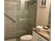 A bright and modern bathroom features tiled walls, glass shower door, grab bar, and updated fixtures at 12478 Capri Circle N # 2, Treasure Island, FL 33706