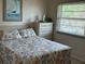 This bedroom features an abundance of natural light from the window, complemented by a classic dresser at 12478 Capri Circle N # 2, Treasure Island, FL 33706