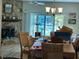 Dining room with a stone fireplace, sliding glass doors leading to the water, and wood chairs at 12478 Capri Circle N # 2, Treasure Island, FL 33706