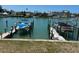Waterfront property featuring boat dock with boat on lift, offering convenient access to the water at 12478 Capri Circle N # 2, Treasure Island, FL 33706