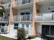 View of balconies with railings, patio with bench and seating, and peachy colored exterior at 12478 Capri Circle N # 2, Treasure Island, FL 33706