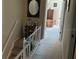 Upstairs hallway featuring wood floors, white railing, and a large mirror at 12478 Capri Circle N # 2, Treasure Island, FL 33706