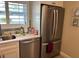 Galley kitchen with stainless steel dishwasher, a stainless refrigerator, and white cabinetry at 12478 Capri Circle N # 2, Treasure Island, FL 33706