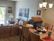 Living area with brown sofas, light wood dining table, and sliding door at 12478 Capri Circle N # 2, Treasure Island, FL 33706