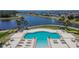 Aerial view of a community pool with seating and a lake at 13506 Wild Ginger St, Riverview, FL 33579