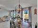 Bright dining room with modern chandelier and view of the backyard through sliding glass doors at 13506 Wild Ginger St, Riverview, FL 33579