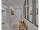 Neutral hallway featuring tile flooring, decorative mirrors, and access to multiple rooms at 13506 Wild Ginger St, Riverview, FL 33579