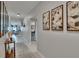 Inviting hallway with elegant decor and art, leading to an open-concept living area at 13506 Wild Ginger St, Riverview, FL 33579