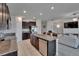Kitchen island with a stainless steel dishwasher, dark wood cabinets, and adjacent living space at 13506 Wild Ginger St, Riverview, FL 33579