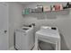 Well-lit laundry room with modern appliances and shelving for storage at 13506 Wild Ginger St, Riverview, FL 33579