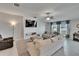 Bright living room featuring tile floors, plush furniture, ceiling fan, and a modern entertainment center with a large screen TV at 13506 Wild Ginger St, Riverview, FL 33579