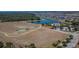 Aerial view of community recreational area featuring tennis courts, and a covered picnic area near the lake at 13506 Wild Ginger St, Riverview, FL 33579