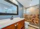 Bathroom featuring wood vanity, large mirror, toilet, and glass-enclosed shower with decorative tile at 13891 Feather Sound Dr, Clearwater, FL 33762