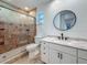 Bathroom featuring a glass enclosed shower, large mirror, and white vanity with granite countertop at 13891 Feather Sound Dr, Clearwater, FL 33762