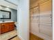 View of bathroom with wooden cabinet and wire rack shelving in the walk-in closet at 13891 Feather Sound Dr, Clearwater, FL 33762