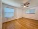 Spacious bedroom featuring bamboo floors, two windows, and a ceiling fan at 13891 Feather Sound Dr, Clearwater, FL 33762