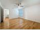 Bright bedroom featuring a ceiling fan, wood floors, and a peek into laundry room at 13891 Feather Sound Dr, Clearwater, FL 33762