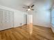 Bright bedroom featuring hardwood floors, a ceiling fan, window, and built in closets at 13891 Feather Sound Dr, Clearwater, FL 33762